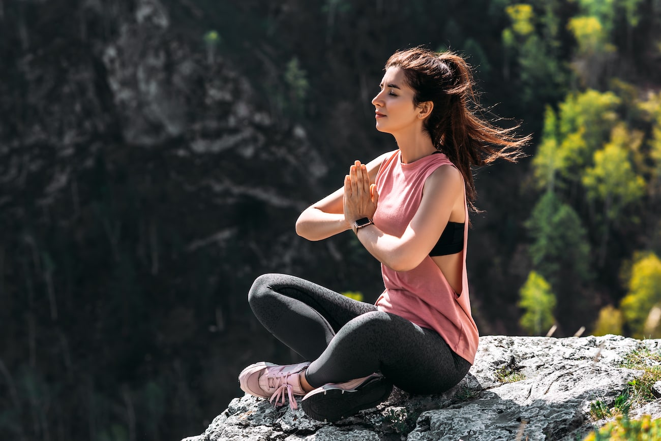 Attractive woman doing yoga. Healthy lifestyle. The concentration of the body. Woman doing yoga in the mountains. Girl doing yoga at sunrise. Woman meditates in nature. Meditation in the mountains bon geste rameur - tirage poignee